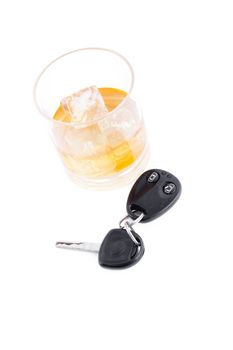 Car key and a whiskey on the rocks against a white background