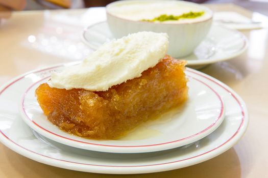 Traditional Turkish dessert Ekmek Tatlisi made with bread and sherbet, served with full milk fat.