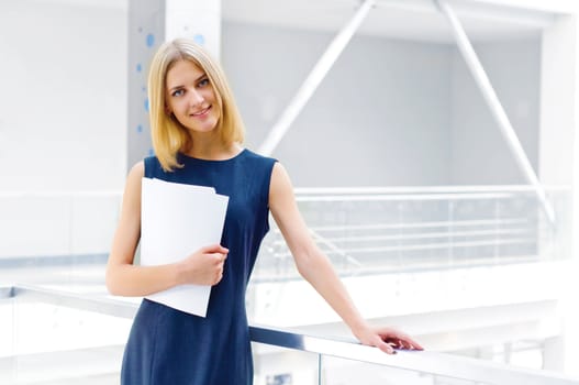 business woman holding reports and looking to the camera, copy space
