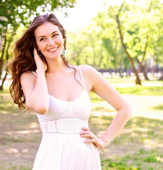 Portrait of an attractive woman in the park, her hair and smiling