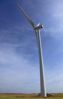 Low angle perspective of a wind turbine in a field.