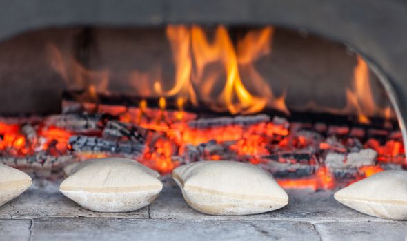 Image of traditional French small breads in front of an ancient firewood oven.