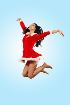 Happy smiling woman in red xmas costume jumping high