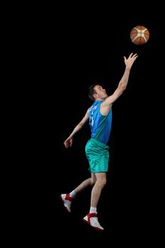 Male basketball player jumping and practicing with a ball