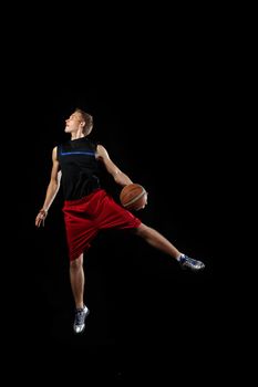 Male basketball player jumping and practicing with a ball