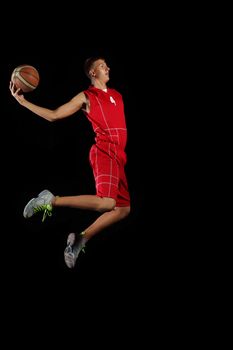 Male basketball player jumping and practicing with a ball