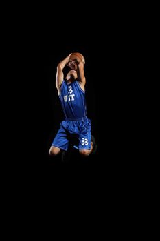 Male basketball player jumping and practicing with a ball