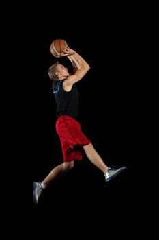 Male basketball player jumping and practicing with a ball