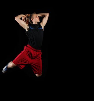 Male basketball player jumping and practicing with a ball