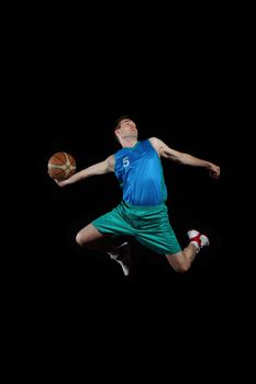 Male basketball player jumping and practicing with a ball