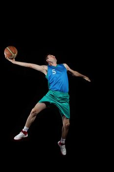 Male basketball player jumping and practicing with a ball