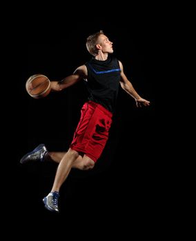 Male basketball player jumping and practicing with a ball