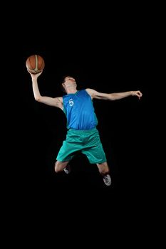 Male basketball player jumping and practicing with a ball