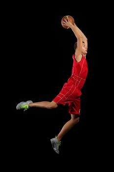 Male basketball player jumping and practicing with a ball