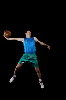 Male basketball player jumping and practicing with a ball