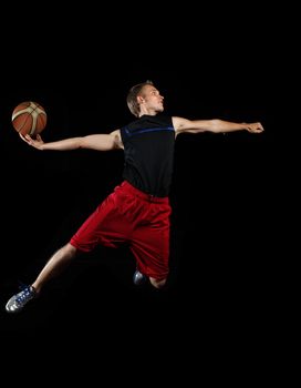 Male basketball player jumping and practicing with a ball