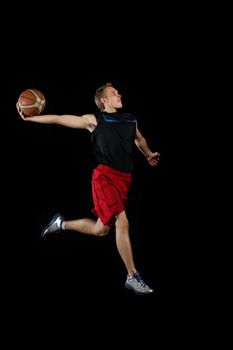 Male basketball player jumping and practicing with a ball