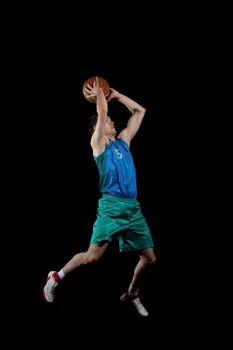 Male basketball player jumping and practicing with a ball