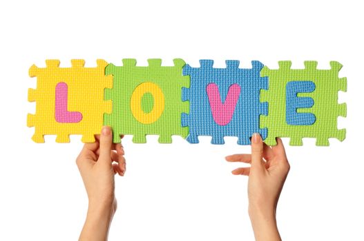 Teacher holding in the hand the amusing colored educational puzzles with the word love
