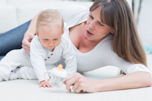 Baby and mother sitting on the floor in living room