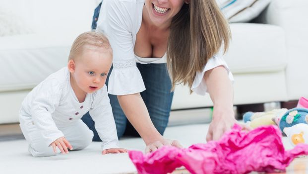 Baby and a mother on all fours in living room