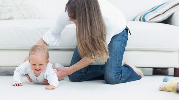 Mother catching a baby in living room