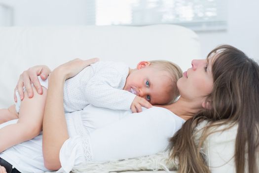 Baby lying on the chest of a mother in living room