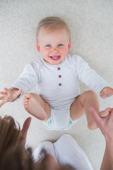 High view of a baby lying on back in living room