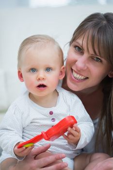 Baby holding a toy in living room