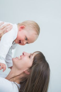 Smiling mother holding her baby in living room