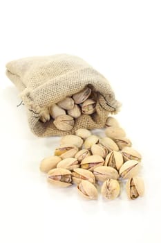 roasted, salted pistachios on a white background