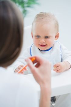 Baby looking at a plastic spoon in living room