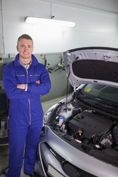 Smiling mechanic standing in a garage