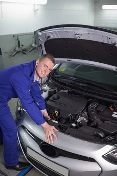 Mechanic repairing a car engine in a garage