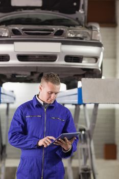 Mechanic touching a tablet computer in a garage