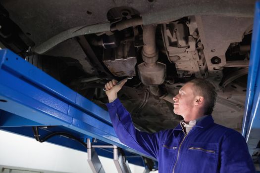 Mechanic repairing with a spanner in a garage