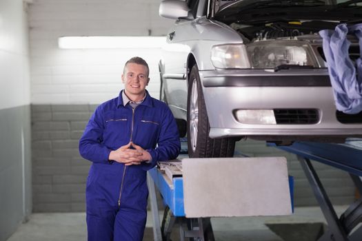 Front view of a smiling mechanic in a garage