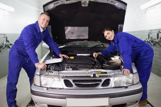 Mechanics leaning on a car in a garage