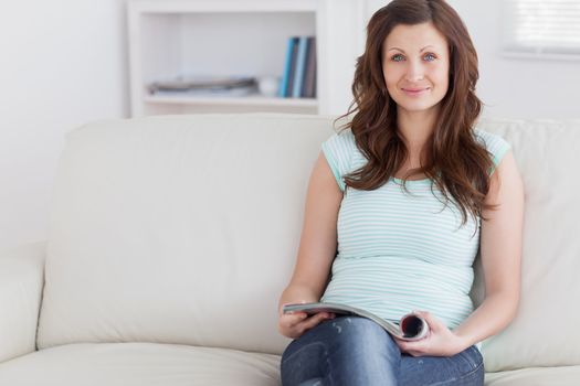 Woman holding a magazine while holding a magazine in a living room