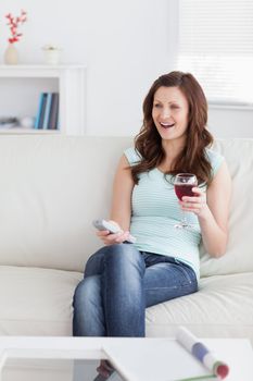 Smiling woman holding a glass of wine in a living room