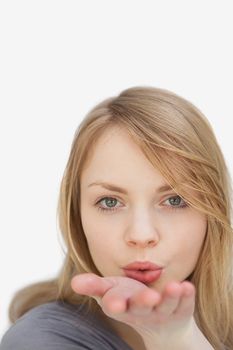 Woman blowing on her hand against a white background