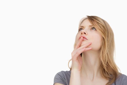 Thoughtful woman looking up against a white background