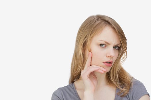 Thoughtful woman looking at camera against a white bacground