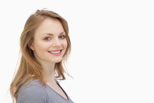 Woman smiling while looking at camera against a white background