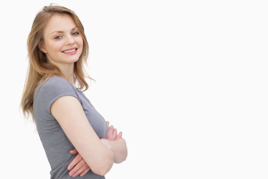 Side view of a woman with arms crossed against a white background