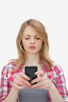 Annoyed woman using a mobile phone against a white background