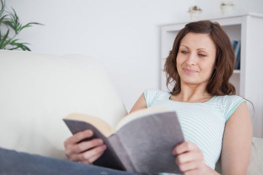 Woman reading a book on a sofa in a living room