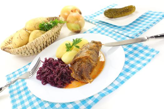fresh cooked Beef roulade with potatoes and red cabbage on a light background