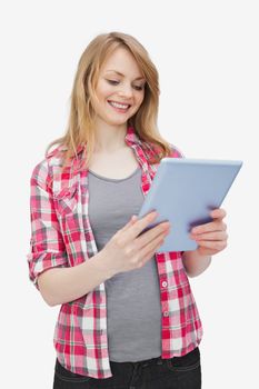 Woman holding a tablet computer while standing against a white background