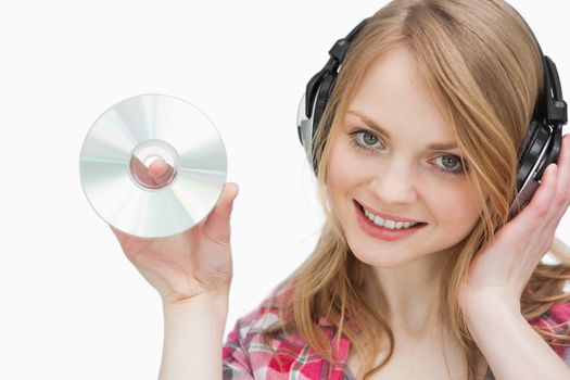 Woman holding a cd while looking at camera against a white background
